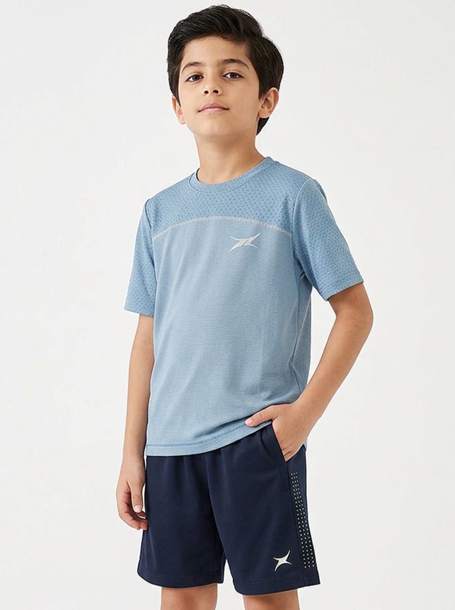 Child wearing a blue sports shirt and navy shorts with a logo on a white background
