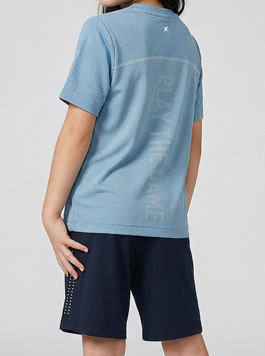 A girl wearing a blue sports T-shirt with text on the back against a white background