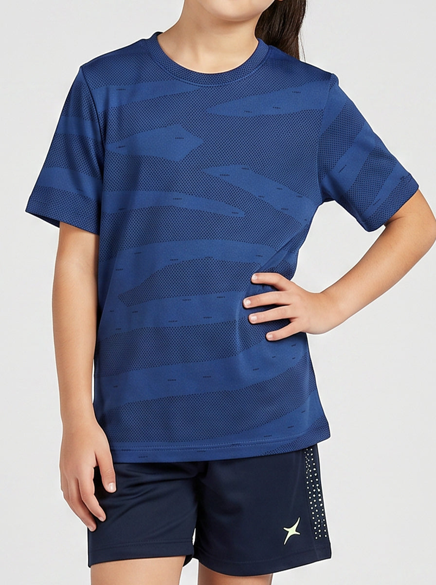 A girl wearing a blue sports t-shirt and shorts on a white background