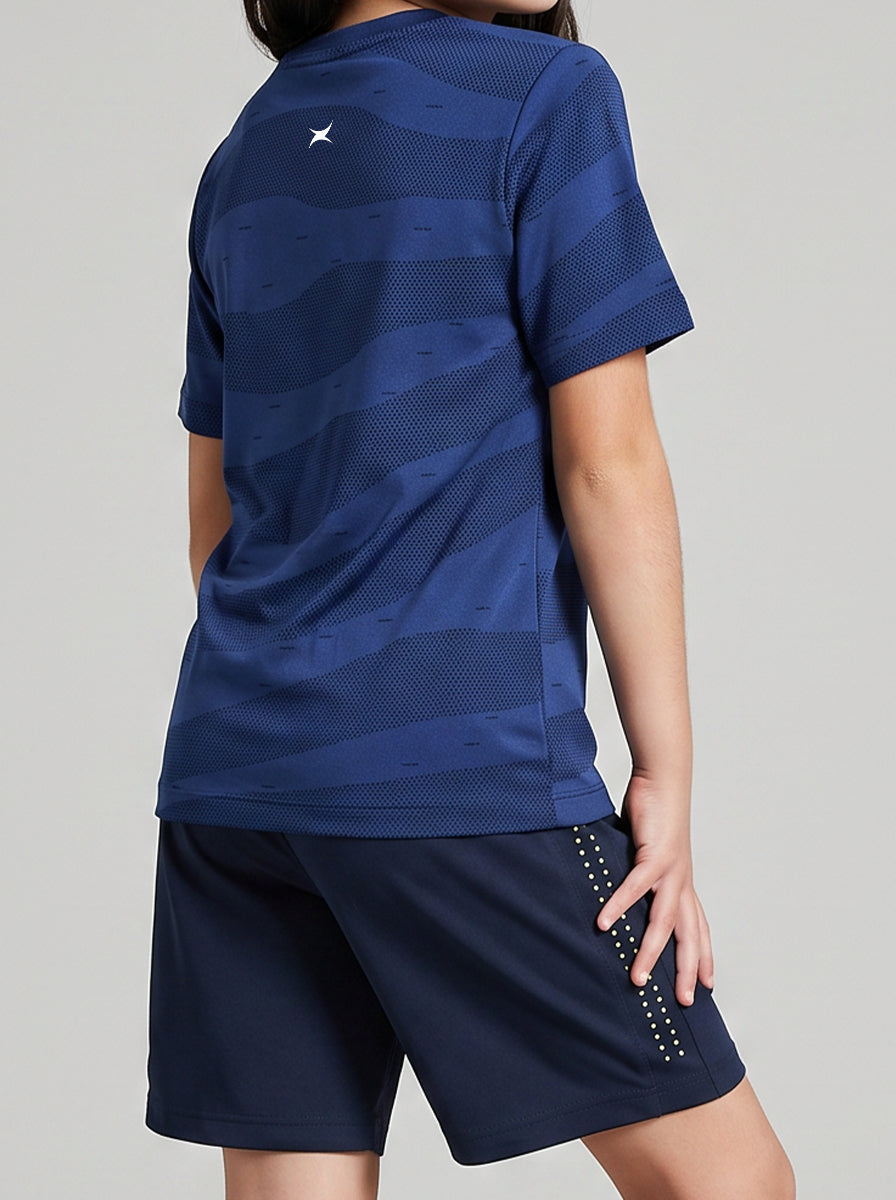 A girl wearing a blue sports outfit with a logo on a gray background