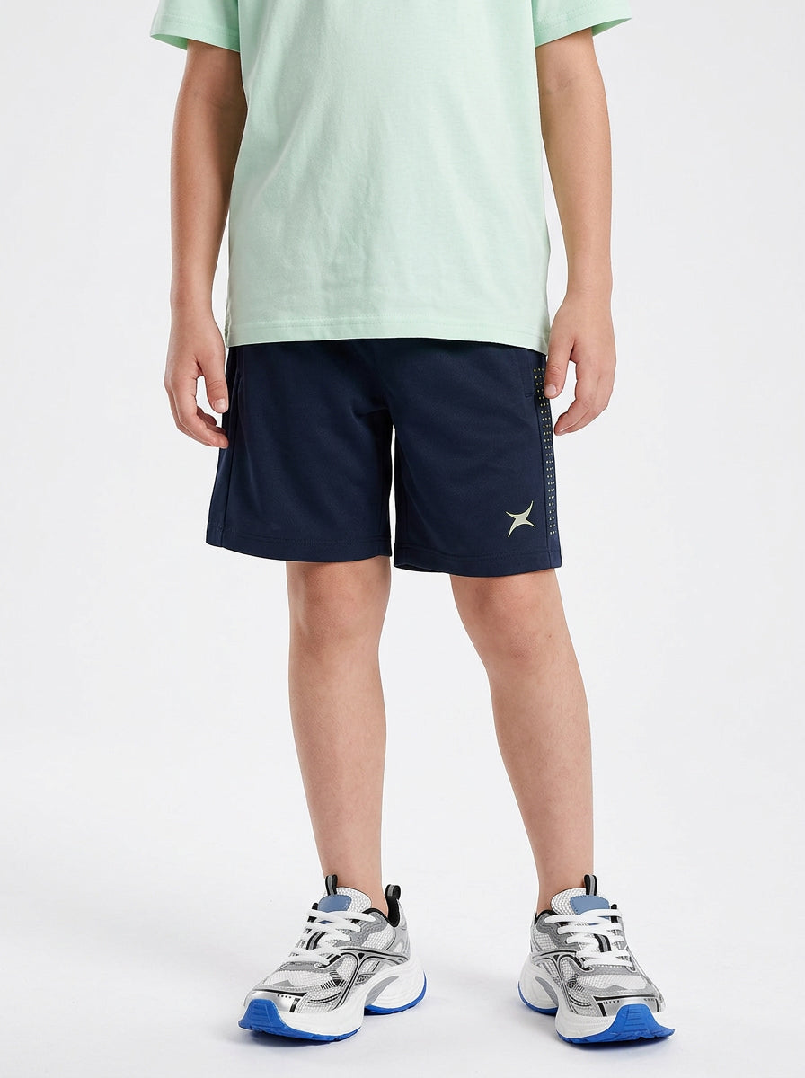 A boy wearing navy shorts with a logo on a white background