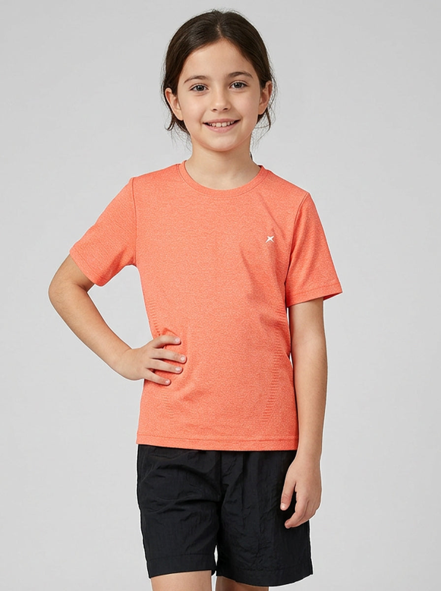 Child wearing an orange sports t-shirt and black shorts on a light gray background