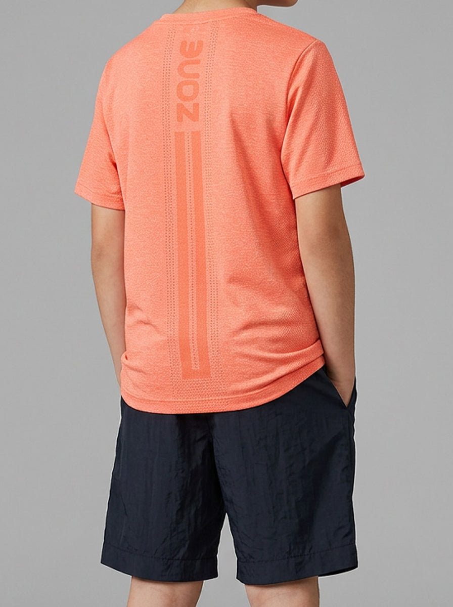 A boy wearing an orange sports t-shirt with 'Zone' branding on the back, paired with navy shorts against a gray background.