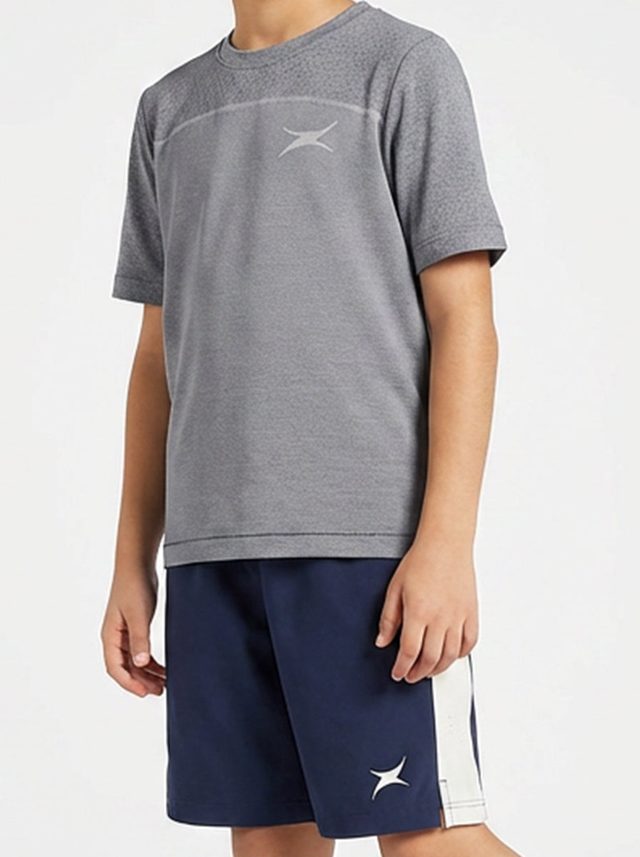 A boy wearing a gray sports t-shirt and navy shorts with a logo on a white background