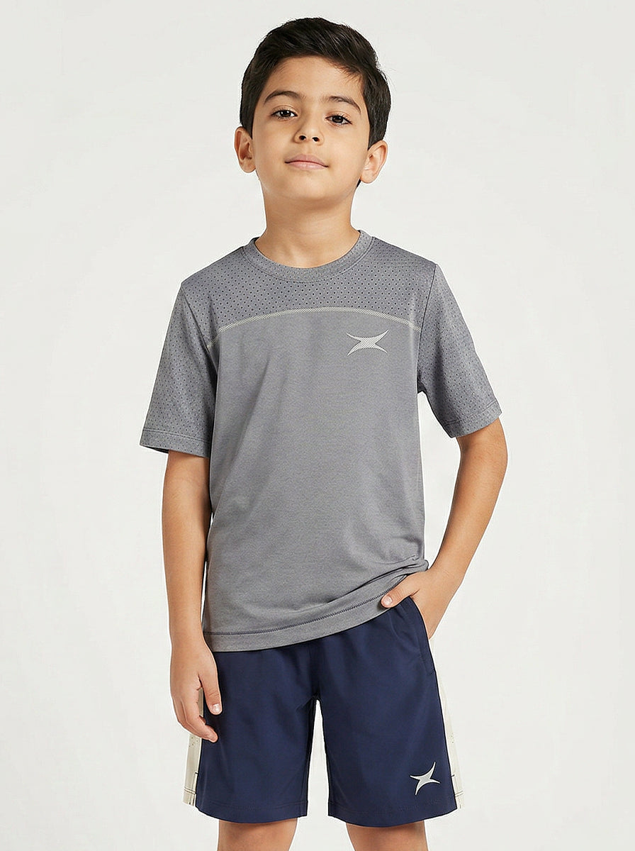 Child wearing a gray sports t-shirt and navy shorts on a white background