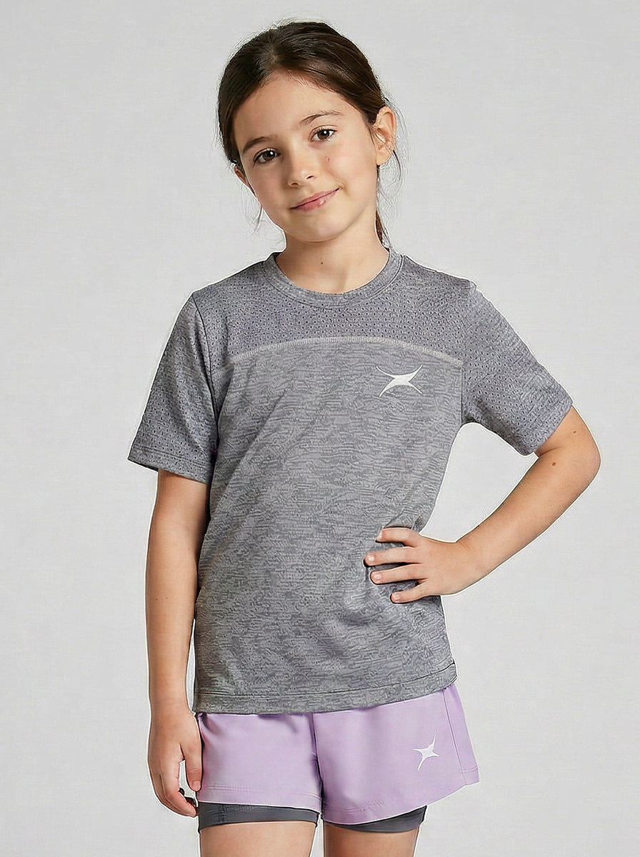 girl wearing a sports t-shirt and purple shorts with a logo on a light gray background