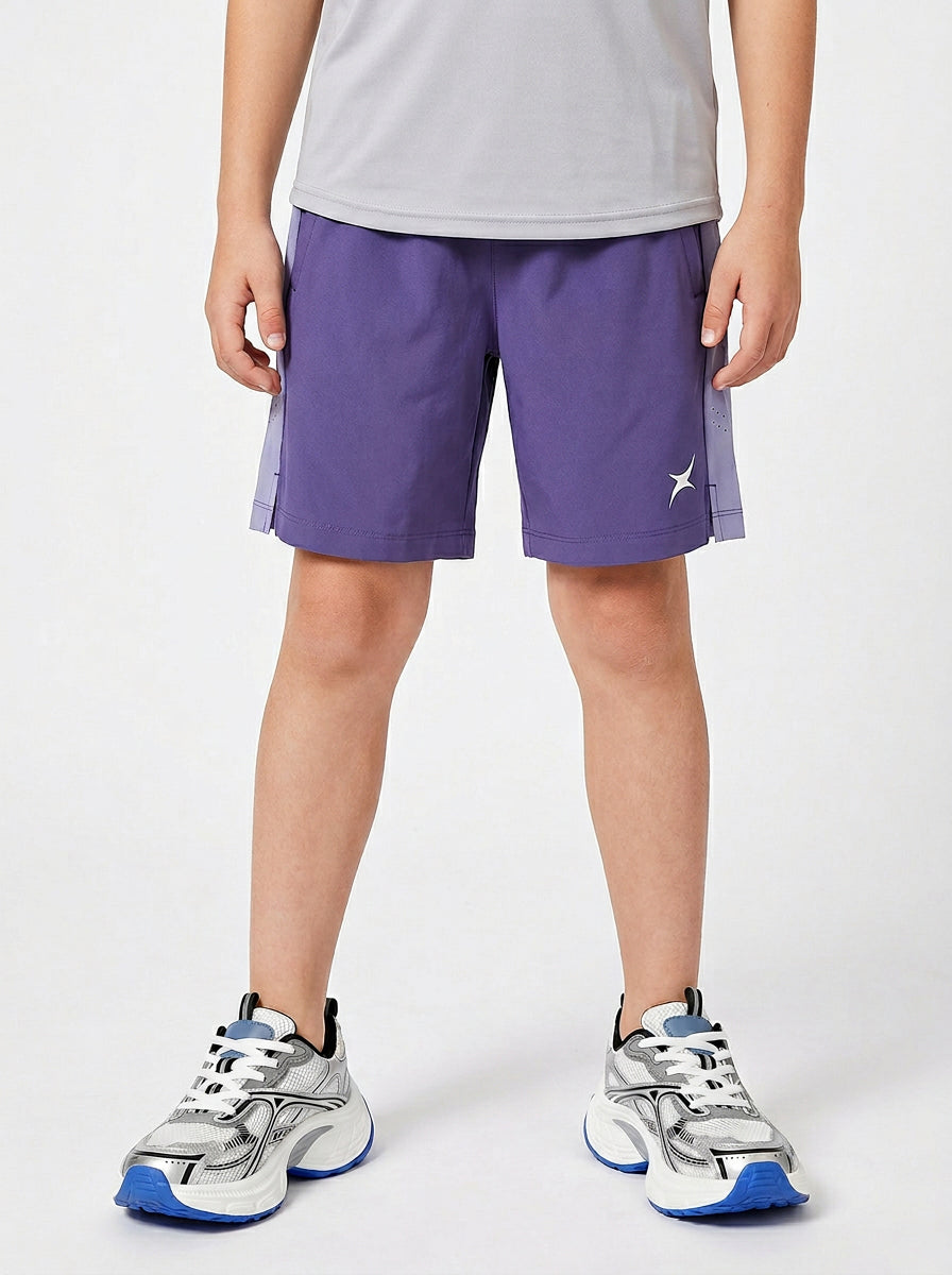 A boy wearing purple shorts with a white logo on a light gray background