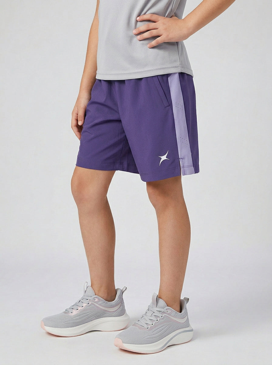A girl wearing lilac shorts with a logo on a light gray background