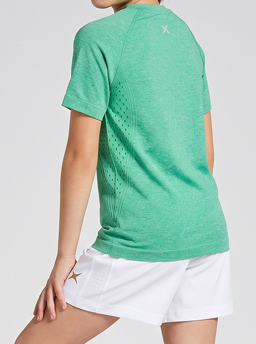 A girl wearing a green t-shirt and white skirt on a light gray background