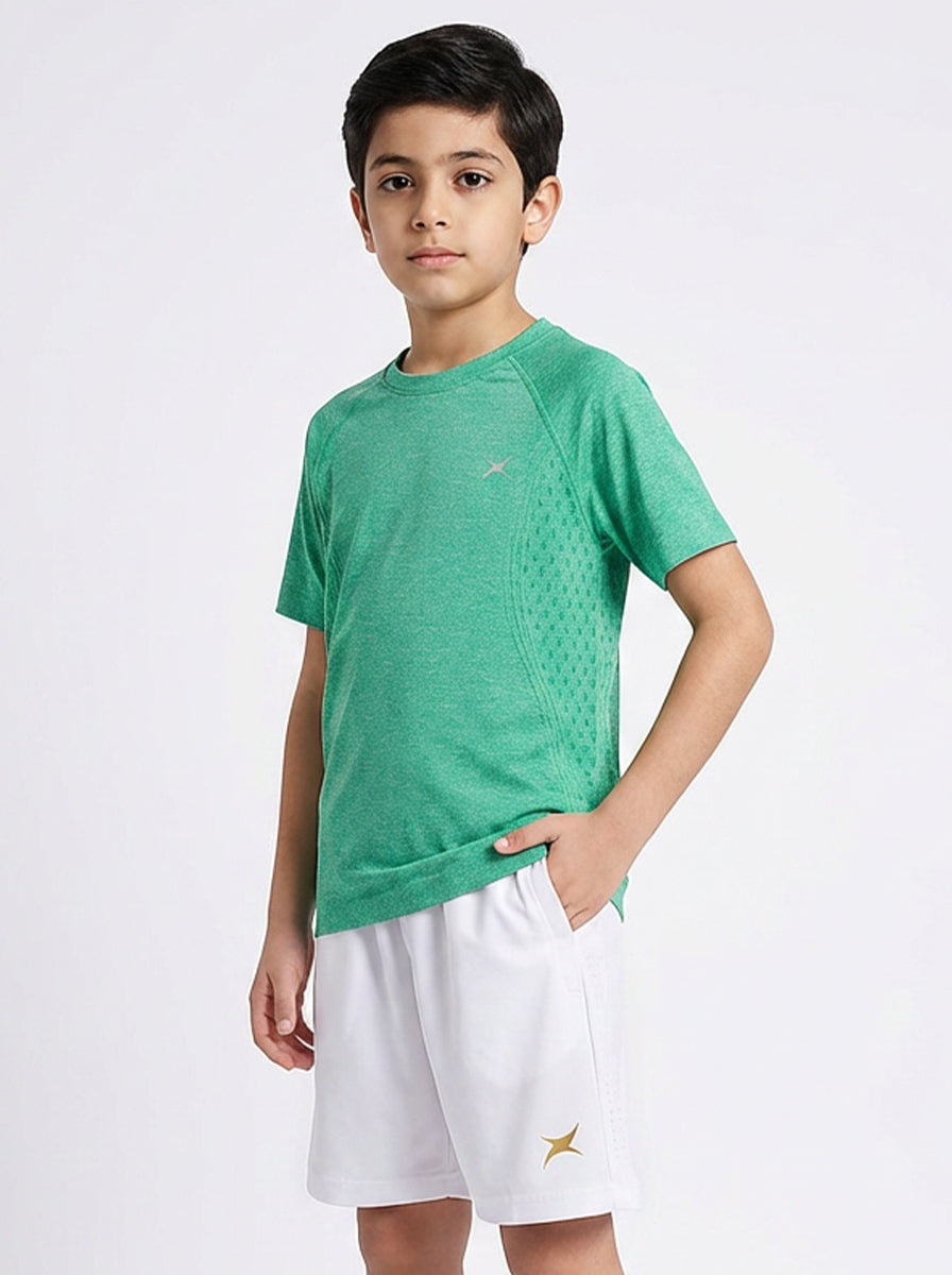 Child wearing a green t-shirt and white shorts on a white background