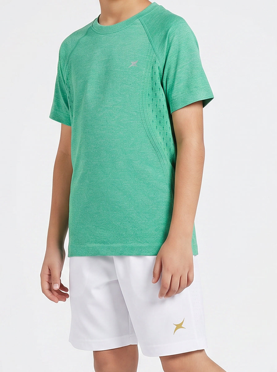 A boy wearing a green t-shirt and white shorts on a white background