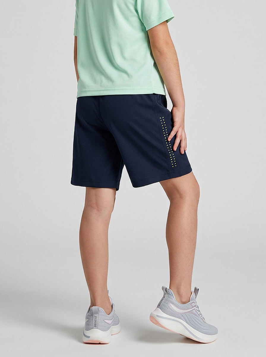 A child wearing navy shorts with a light gray background