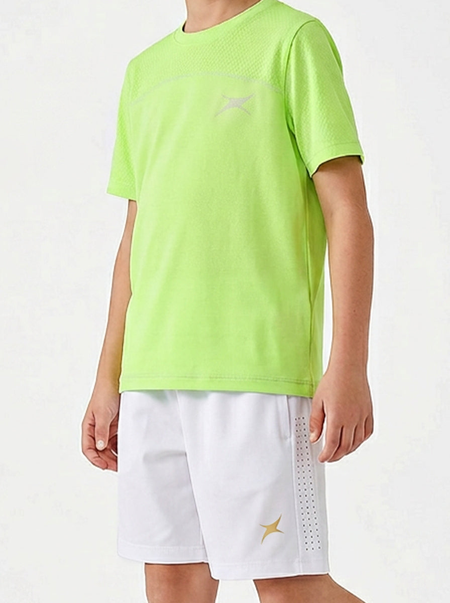 Child wearing a bright green sports t-shirt and white shorts on a light gray background