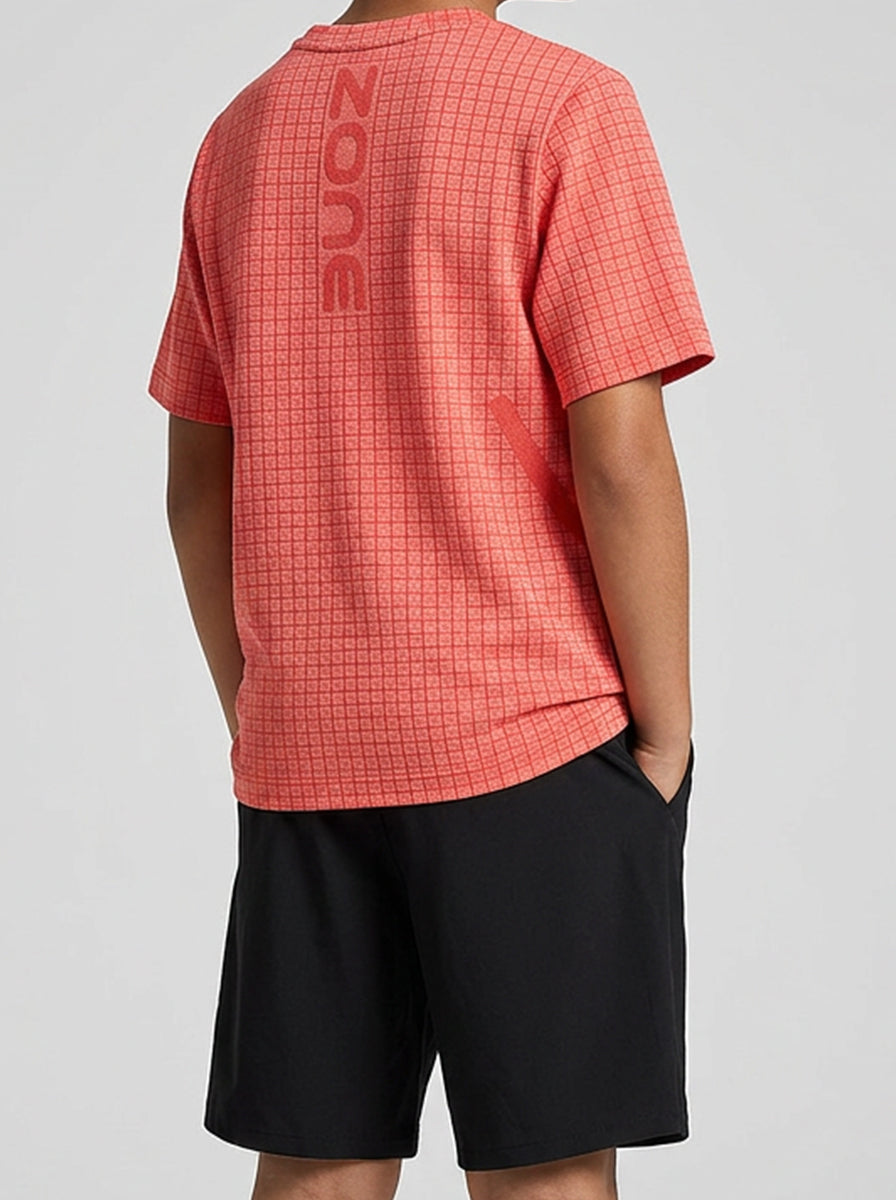 Child wearing an orange checkered sports t-shirt and black shorts with orange trim on a white background