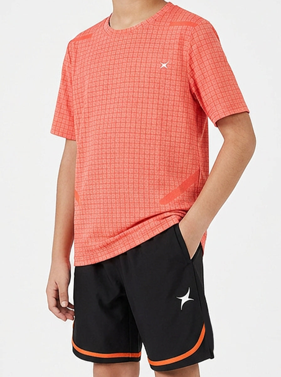 Child wearing an orange checkered sports t-shirt and black shorts with orange trim on a white background