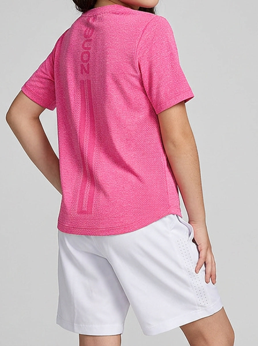 A girl wearing a pink T-shirt with 'Zone' branding and white shorts on a gray background