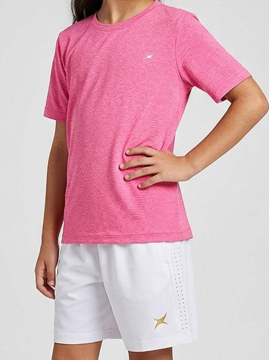 A girl wearing a pink t-shirt and white shorts with a logo on a light gray background