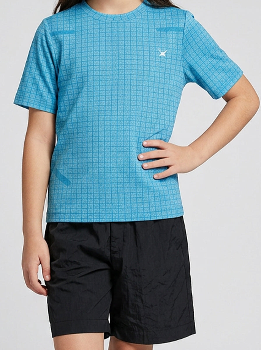 A girl wearing a blue checkered sports t-shirt and black shorts on a white background
