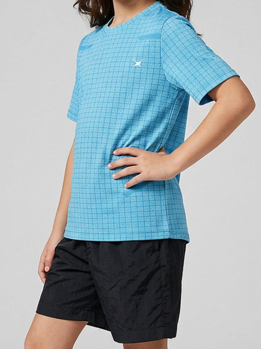 A girl wearing a blue checkered sports T-shirt and black shorts on a gray background