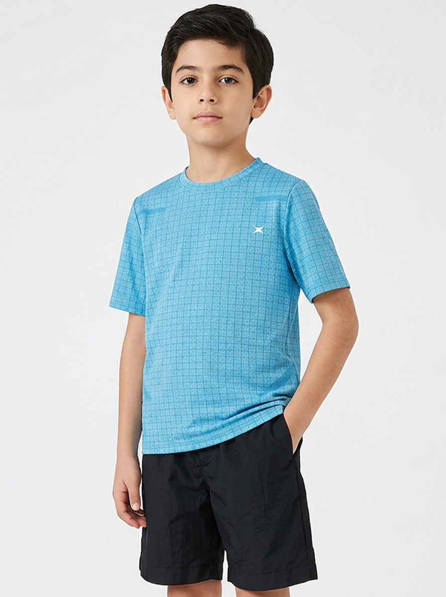 Child wearing a blue checkered sports t-shirt and black shorts on a white background