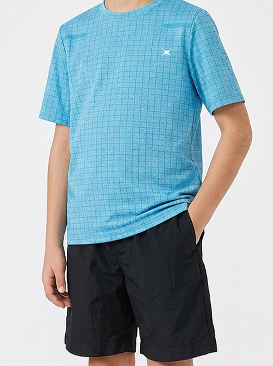 Child wearing a blue checkered sports t-shirt and black shorts on a white background