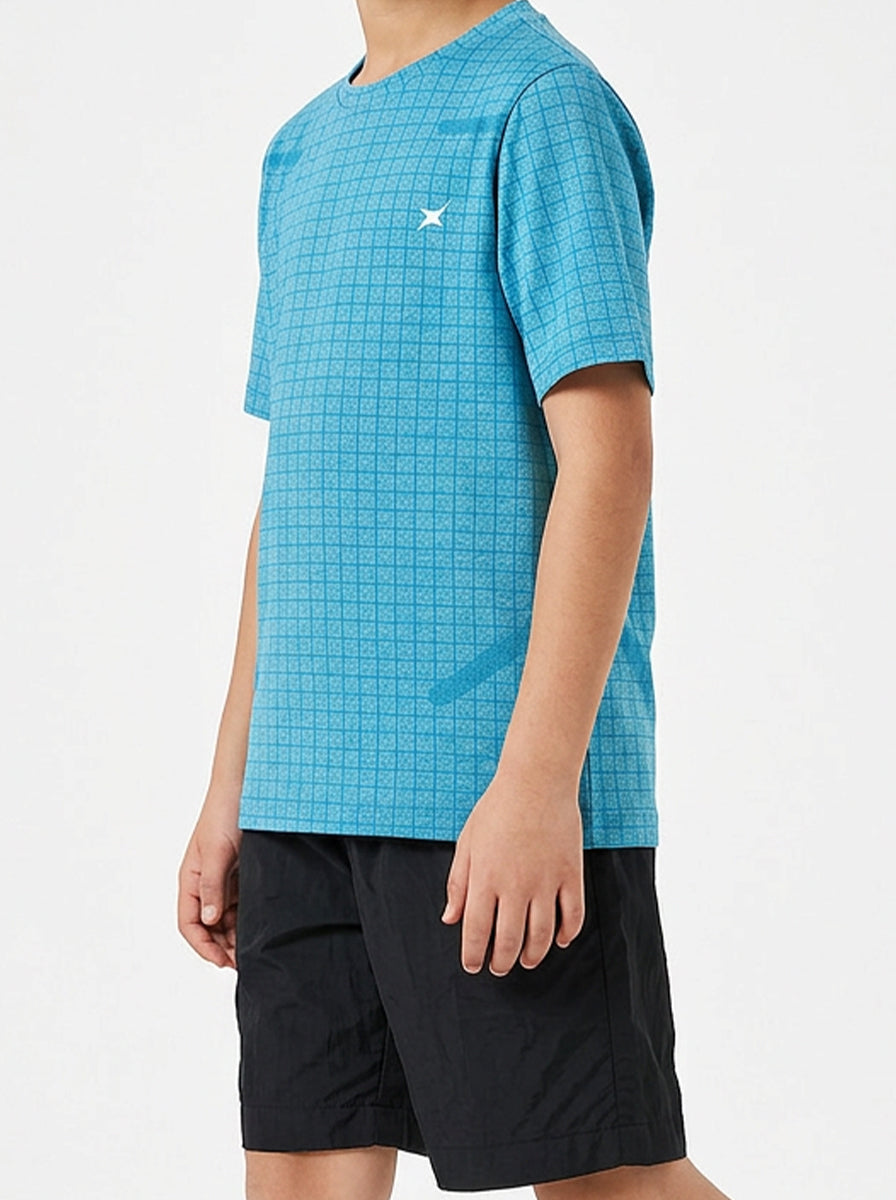 Child wearing a blue checkered sports t-shirt and black shorts on a white background
