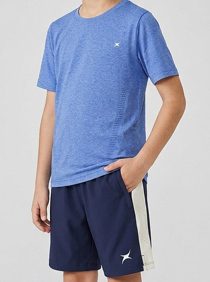 A boy wearing a blue sports t-shirt and navy shorts with a white stripe on a light gray background