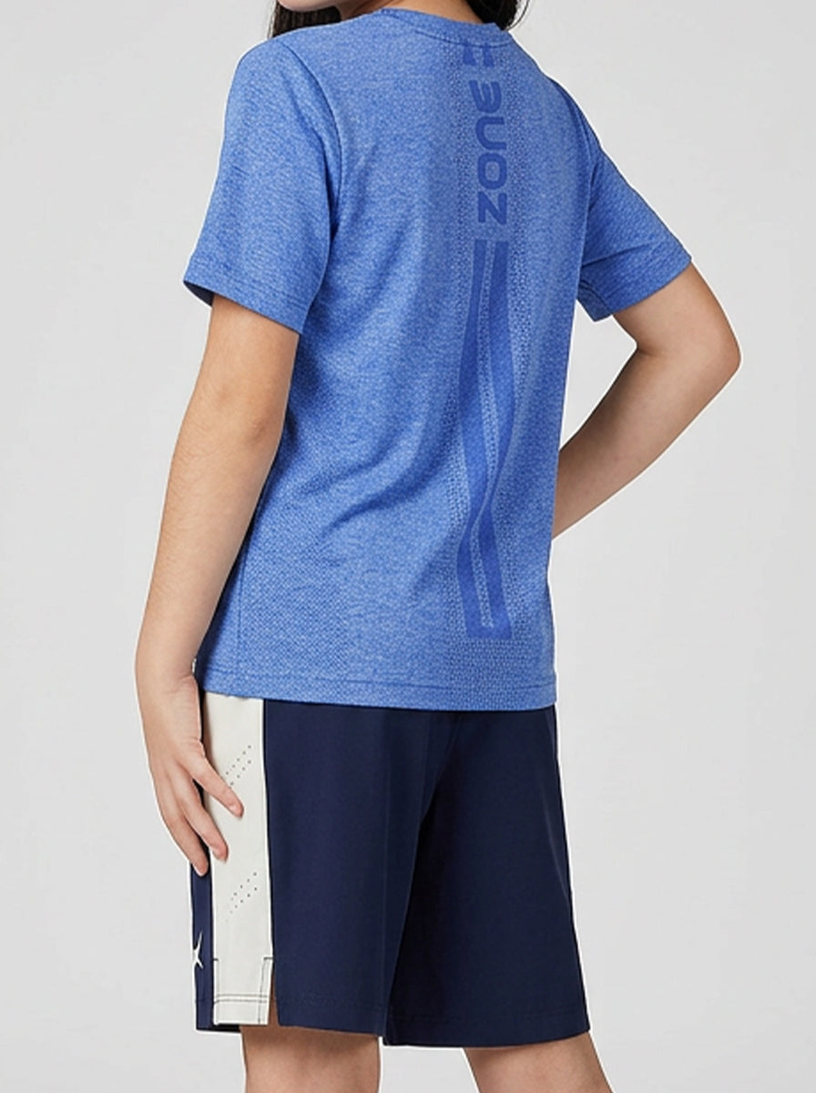 A girl wearing a blue sports T-shirt with branding on the back, standing against a plain background.