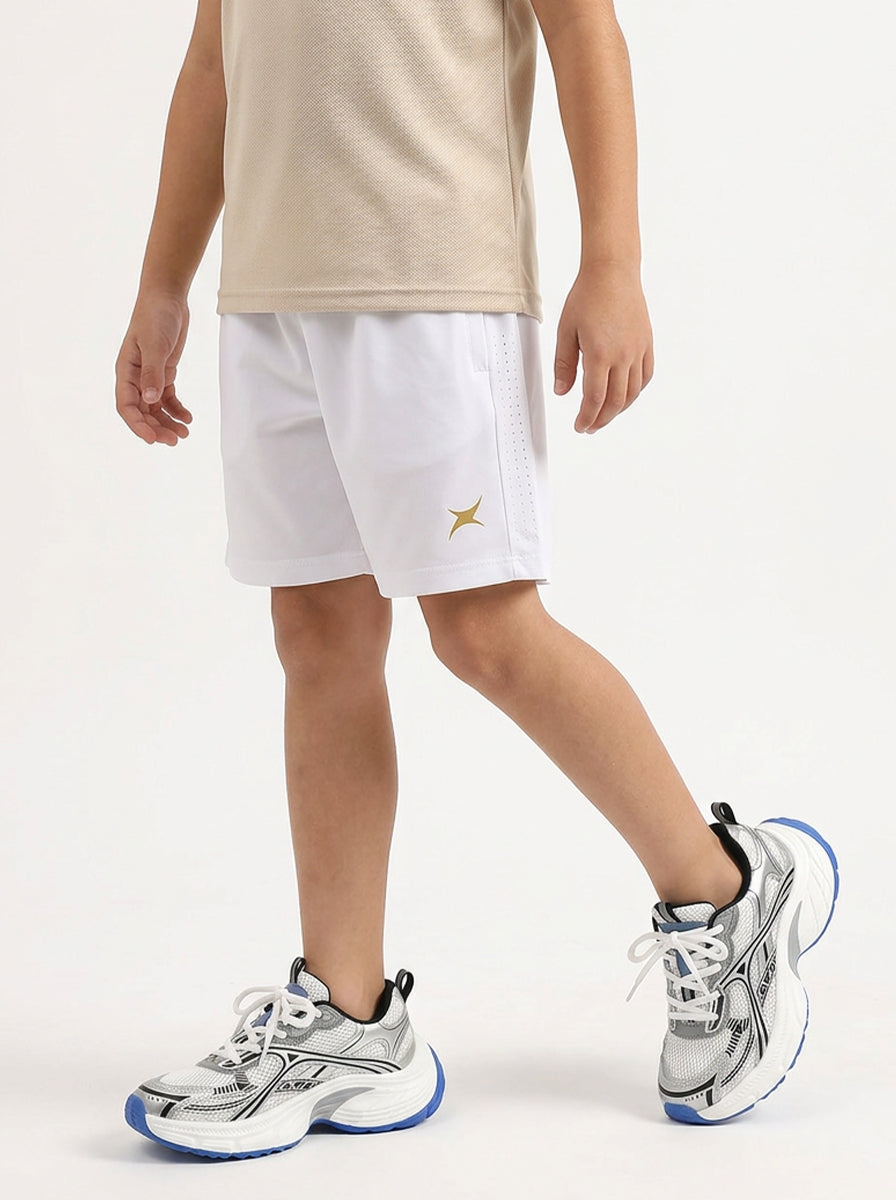 A boy wearing white athletic shorts with a logo on a light gray background