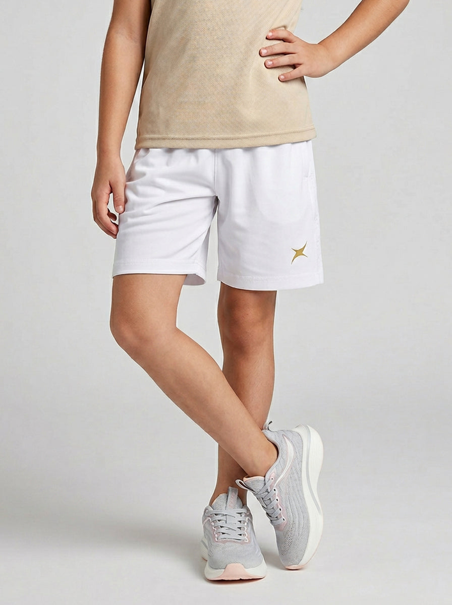 A boy wearing white shorts with a logo on a plain background