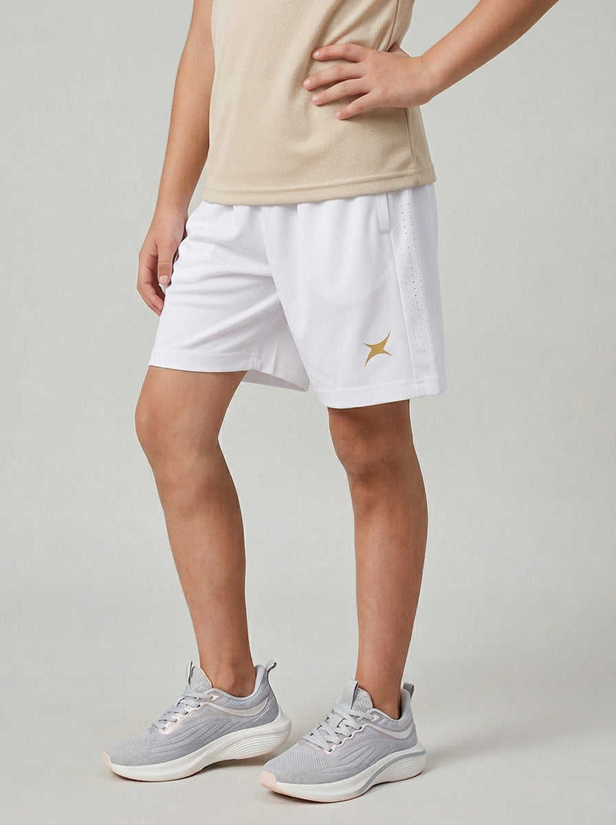 A boy wearing white shorts with a small logo on a plain background