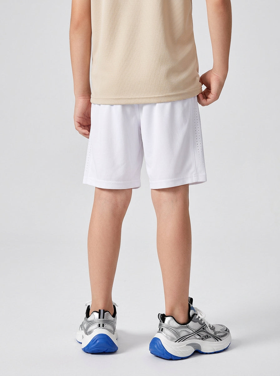 A boy wearing white shorts on a plain background